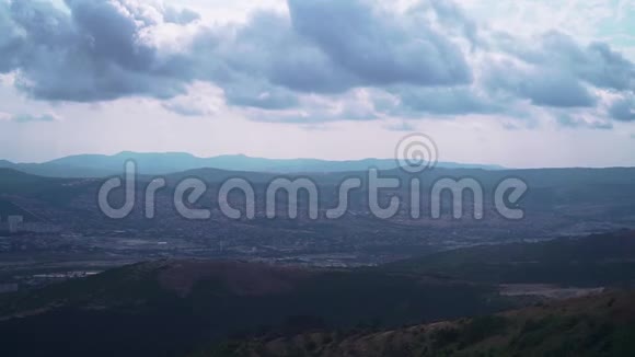 从山顶看青山上的风景在夏天的阴天城市在地平线上视频的预览图