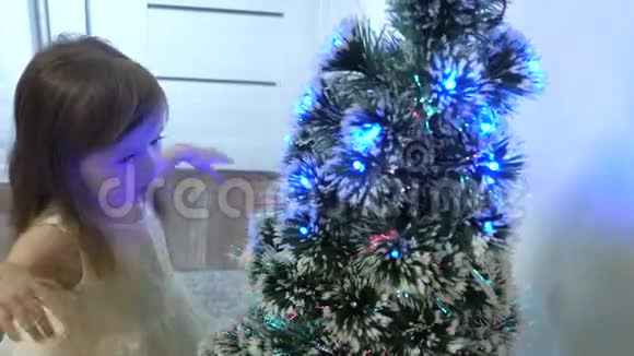 小孩子在儿童房的圣诞树旁玩耍美丽的人工圣诞树快乐童年概念视频的预览图
