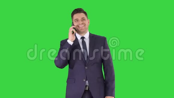 成功的西装男会打电话走在绿色屏幕上铬键视频的预览图