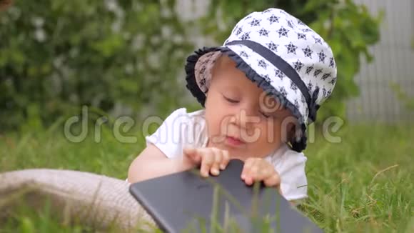 小女孩玩小玩意儿童和新技术幼儿在绿草上玩耍视频的预览图