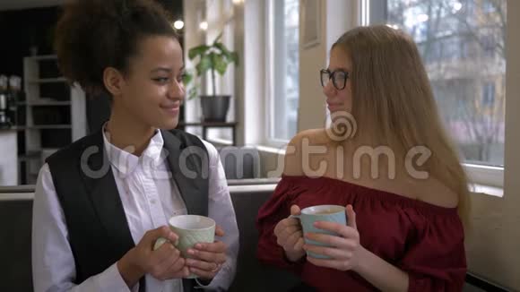 混合种族朋友的肖像女孩在咖啡馆里喝杯茶微笑着休闲视频的预览图