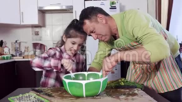 男人和女孩在绿色塑料大碗里混合快速液体视频的预览图