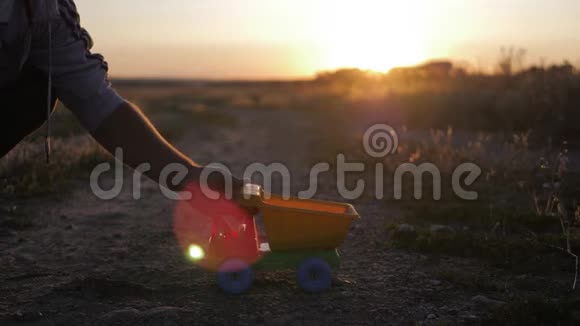 玩具卡车在日落时用沙子或砾石填充施工交通繁忙的概念视频的预览图