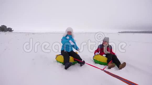 快乐的妈妈孩子们冬天在雪地里溜冰玩雪球圣诞节期间一家人在冬季公园玩耍视频的预览图