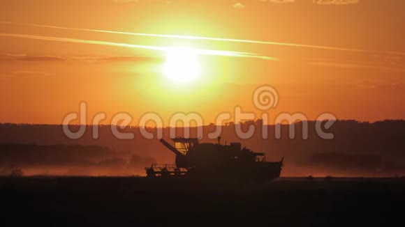 日落时小麦收割机剪影视频的预览图