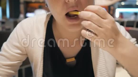 女人正在吃薯条快餐嘴巴特写视频的预览图