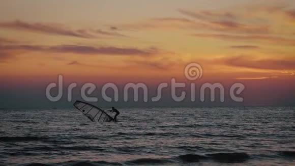 日落时在海上冲浪板上美丽女孩的剪影户外活动的生活方式视频的预览图