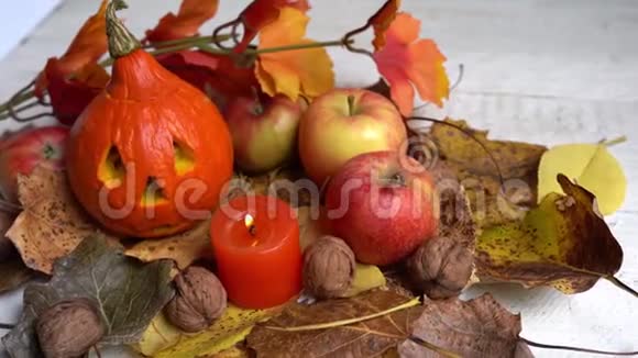 蜡烛苹果南瓜木桌上的秋叶万圣节视频的预览图