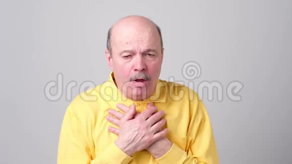 成熟的西班牙裔男子穿黄色t恤男子咳嗽生病视频的预览图