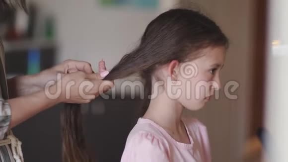 妈妈编辫子梳着有点心烦意乱的女儿视频的预览图