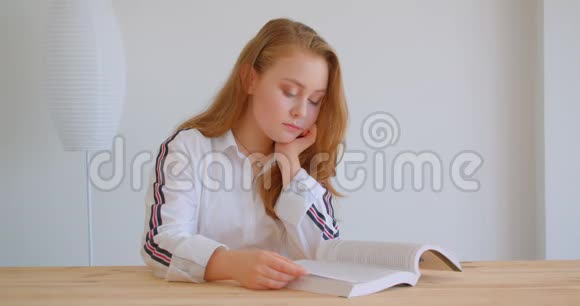 年轻漂亮的白种人女孩在公寓里读书的特写镜头视频的预览图