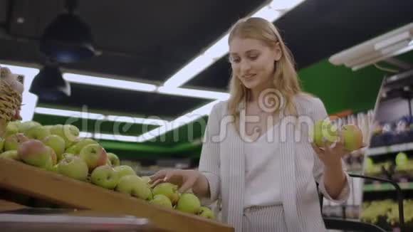有魅力的年轻女性在水果蔬菜超市市场选择苹果视频的预览图