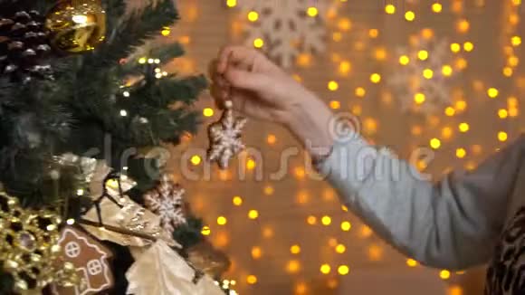 女人或女孩的手在圣诞节或新年装饰圣诞树她把木制玩具挂在上面视频的预览图