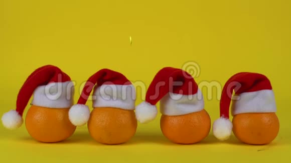 彩纸屑装饰落在一些橘子上的圣诞老人红帽子新年或圣诞节的概念视频的预览图