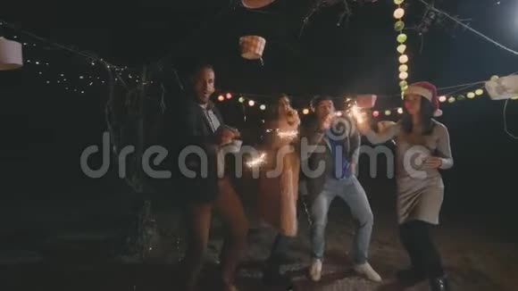 嬉皮士朋友在海滩上跳舞唱歌喝酒摇一摇孟加拉火花视频的预览图