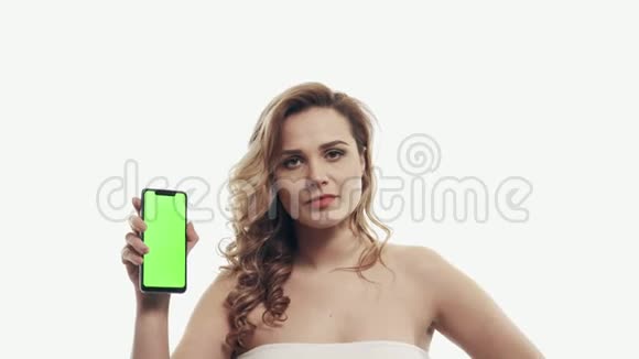 苦恼的女人指着绿色的智能手机屏幕视频的预览图