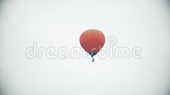 一个橙色的气球在白色乌云密布的天空中飞行视频的预览图