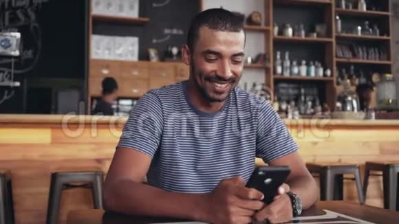 咖啡馆里一个微笑的男人用智能手机的画像视频的预览图