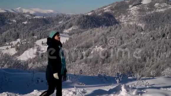 年轻漂亮的女人走过山里的冬林她高兴女人看自然霜天晴视频的预览图