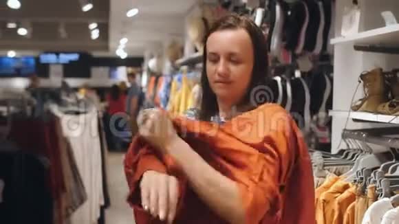 在服装店试穿衣服的女人女人在商店里挑选衣服视频的预览图