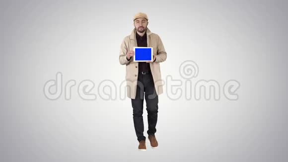 有吸引力的男人拿着平板电脑蓝色的关键屏幕模型在梯度背景视频的预览图