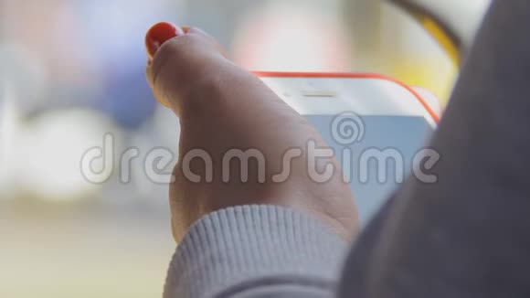 一个穿着浅色针织衫的女孩手里拿着手机视频的预览图
