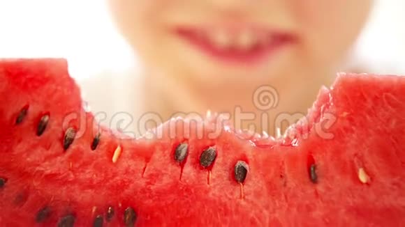 快乐的男孩开胃地吃着红色的西瓜和在牙齿下流动的果汁视频的预览图
