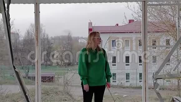 这个女孩站在一座被废弃的被摧毁的建筑里开始从里面出来视频的预览图