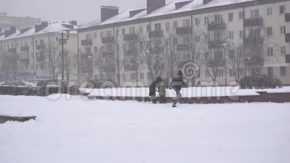 在冬天的城市里家人打雪球下雪新年假期慢动作视频的预览图