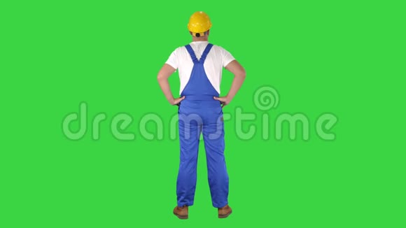 工程师在建筑头盔站立双手在臀部环顾四周的绿色屏幕铬键视频的预览图