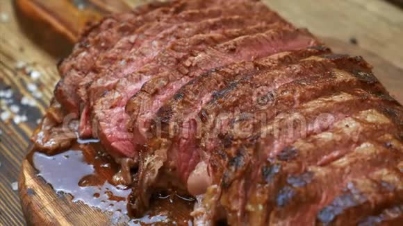 木切割板上夹有香料的切肉牛肉牛排视频的预览图