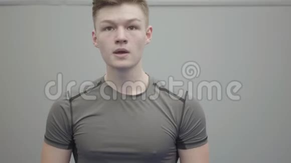 一个自信的年轻人戴着手套拳打脚踢展示了他在健身房的技巧青年视频的预览图