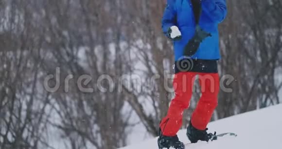 滑雪者向站在滑雪坡上的摄像机投掷雪球视频的预览图