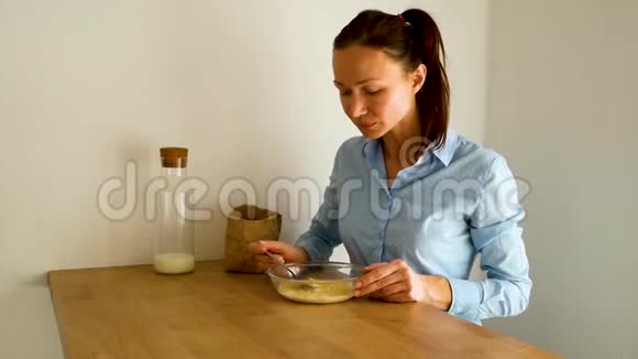 早上在厨房吃牛奶和玉米片作为早餐的年轻女人视频的预览图