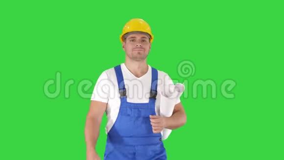 建筑工人带着蓝色的指纹走着微笑着在绿色屏幕上拍摄Chroma键视频的预览图