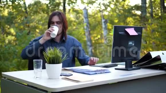 男人在新鲜空气中工作喝咖啡视频的预览图