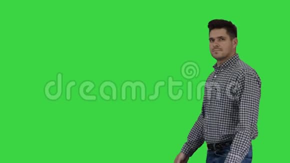 休闲男子与刷子和一些液体看什么油漆和微笑的相机上的绿色屏幕铬键视频的预览图