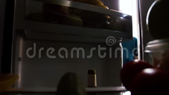 从家里厨房的冰箱里拿果汁的女人视频的预览图