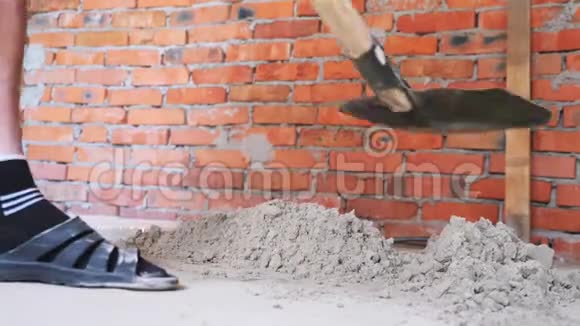 砖砌围墙前用铁锹挖砂职业工匠用铲子挖沙子建设概念视频的预览图