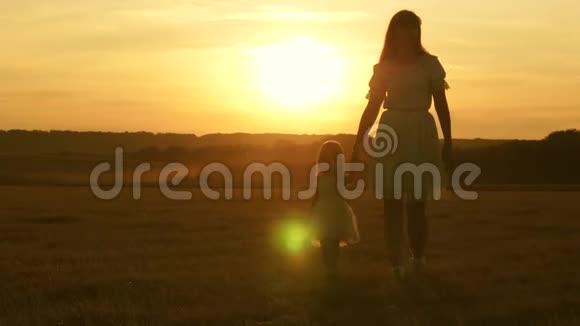 快乐的孩子和他的母亲在草地上玩耍小女儿和妈妈牵着手在田野里走来走去婴儿抱视频的预览图