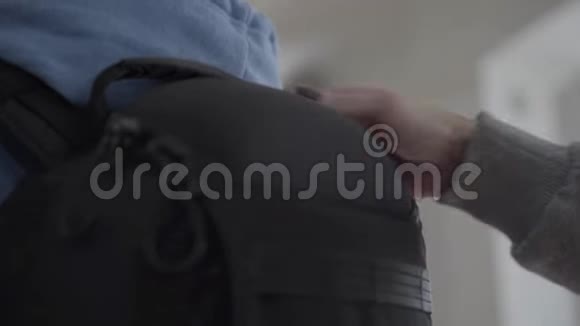 背上一个黑色舒适的背包特写女人的手在后面固定包视频的预览图