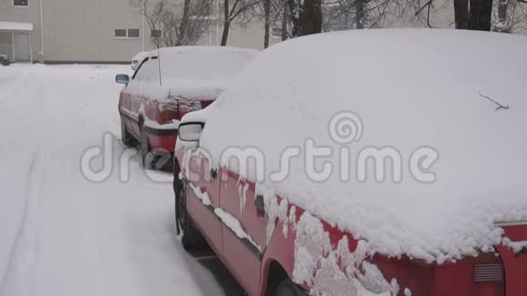 城市里白雪覆盖的汽车背景冬天慢动作视频的预览图