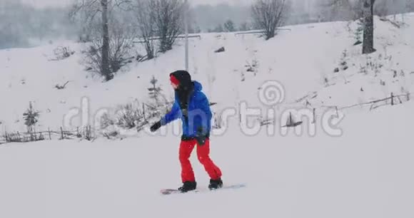 男子滑雪板骑在滑雪坡的雪板上慢动作视频的预览图