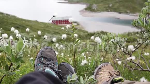 两个旅行者坐在挪威峡湾上方的山上视频的预览图