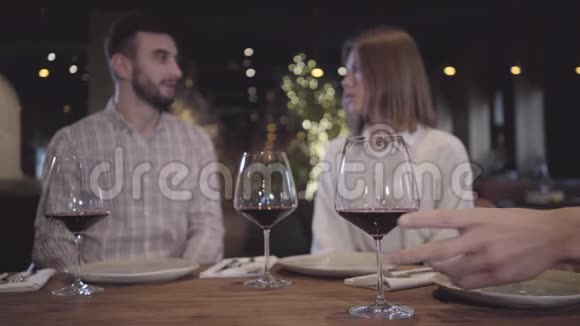 坐在现代舒适的餐厅里一个留着胡须的男人和优雅的女人在后台说话视频的预览图