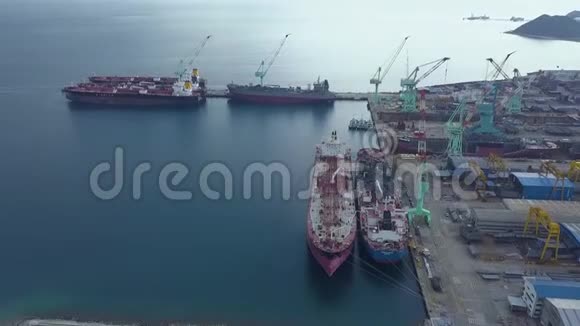 工业船厂的航空景观货船停泊在码头无人机停车场的海上船只视频的预览图