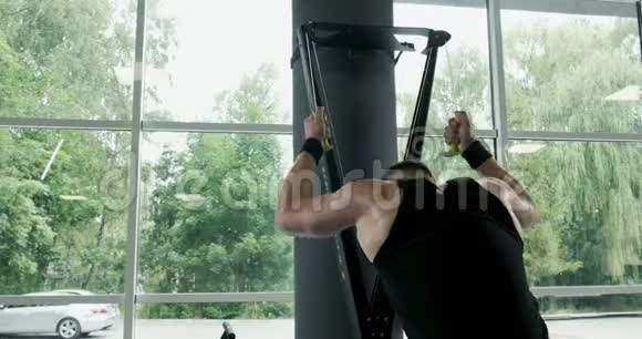 强壮的肌肉男在滑雪板模拟器上工作健身房交叉健身训练视频的预览图