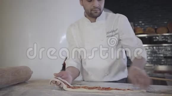 厨师穿着白色制服在现代餐厅厨房里制作土耳其阿拉伯食品男人从桌子上拿面团视频的预览图