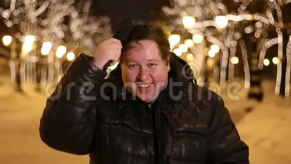 冬天寒冷的夜晚一个快乐的年轻人在户外梳头视频的预览图