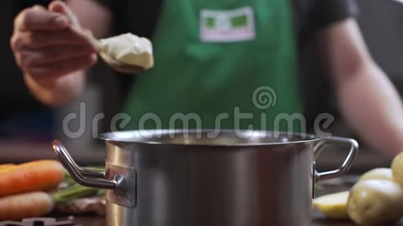 厨师在做菜的时候在餐中加入奶油奶酪厨师把一些蓖麻放进不锈钢锅里做成泥状视频的预览图